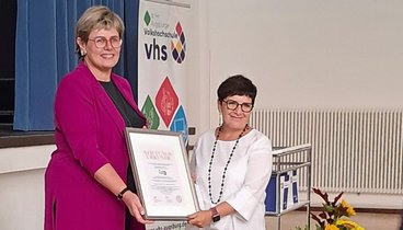 Cornelia Kollmer, stellvertretende Vorstandsvorsitzende der Stadtsparkasse Augsburg, überreichte zum 120. Geburtstag der Augsburger vhs die neue Stiftung „Gemeinsam Bildung schaffen“ an Marina Bilotta Gutheil, Vorständin der Augsburger vhs. Foto: Augsburger vhs